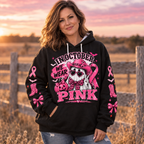 Woman wearing the In October We Wear Pink hoodie in a field at sunset