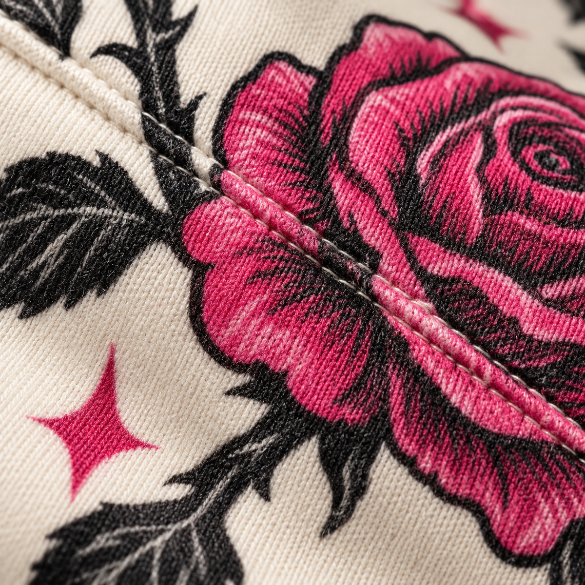 Close-up of the rose print running across a stitched seam on the knit fabric