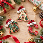 Three wooden initial ornaments with Santa hats and 2026, flat lay