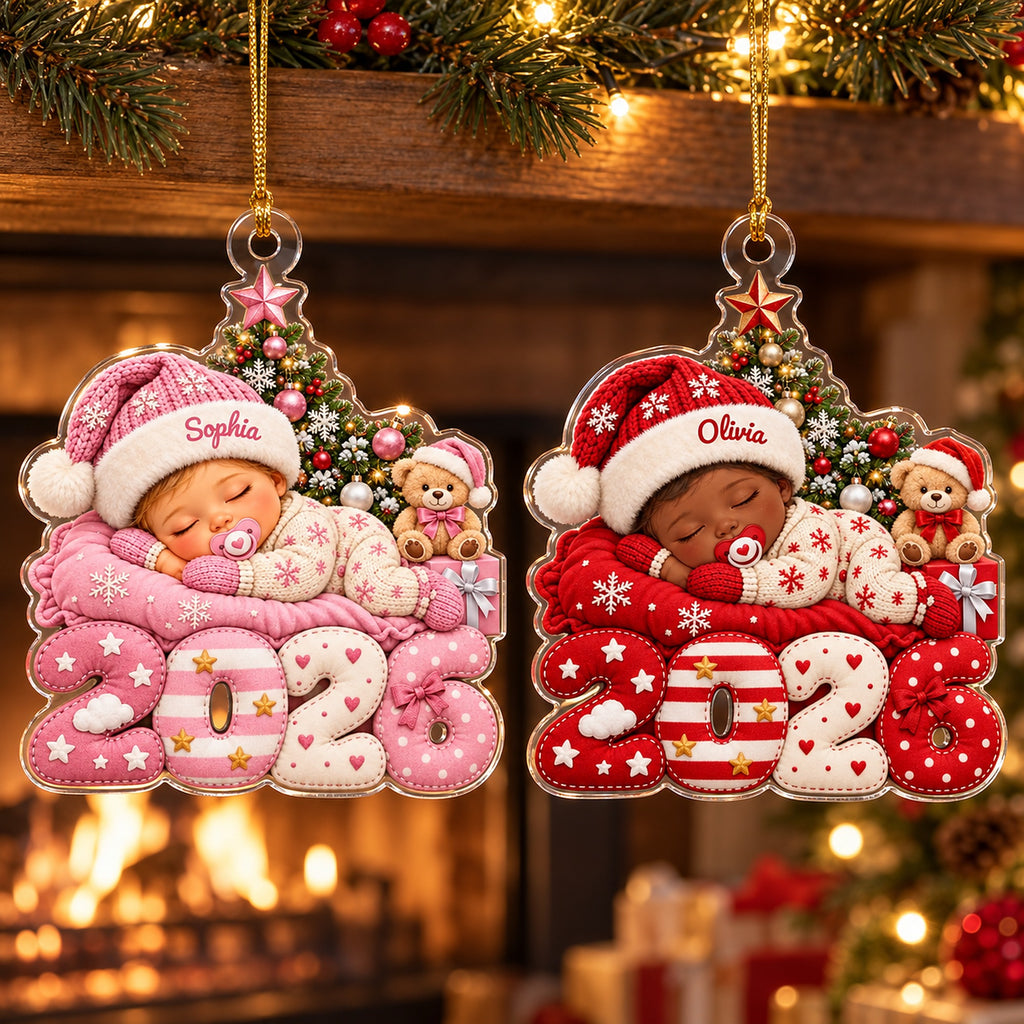 Pink and red baby 2026 ornaments with names Sophia and Olivia by a fireplace
