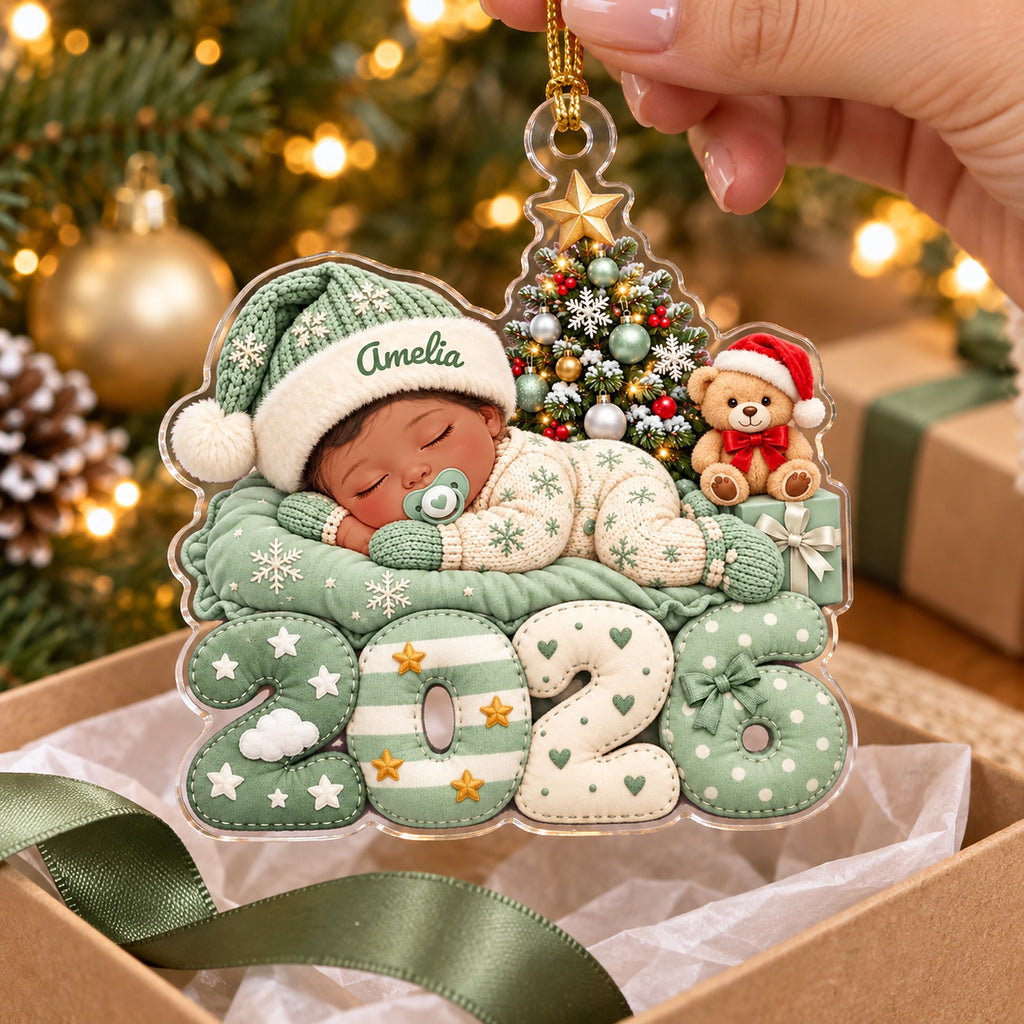 Green baby 2026 ornament with name Amelia held over a gift box